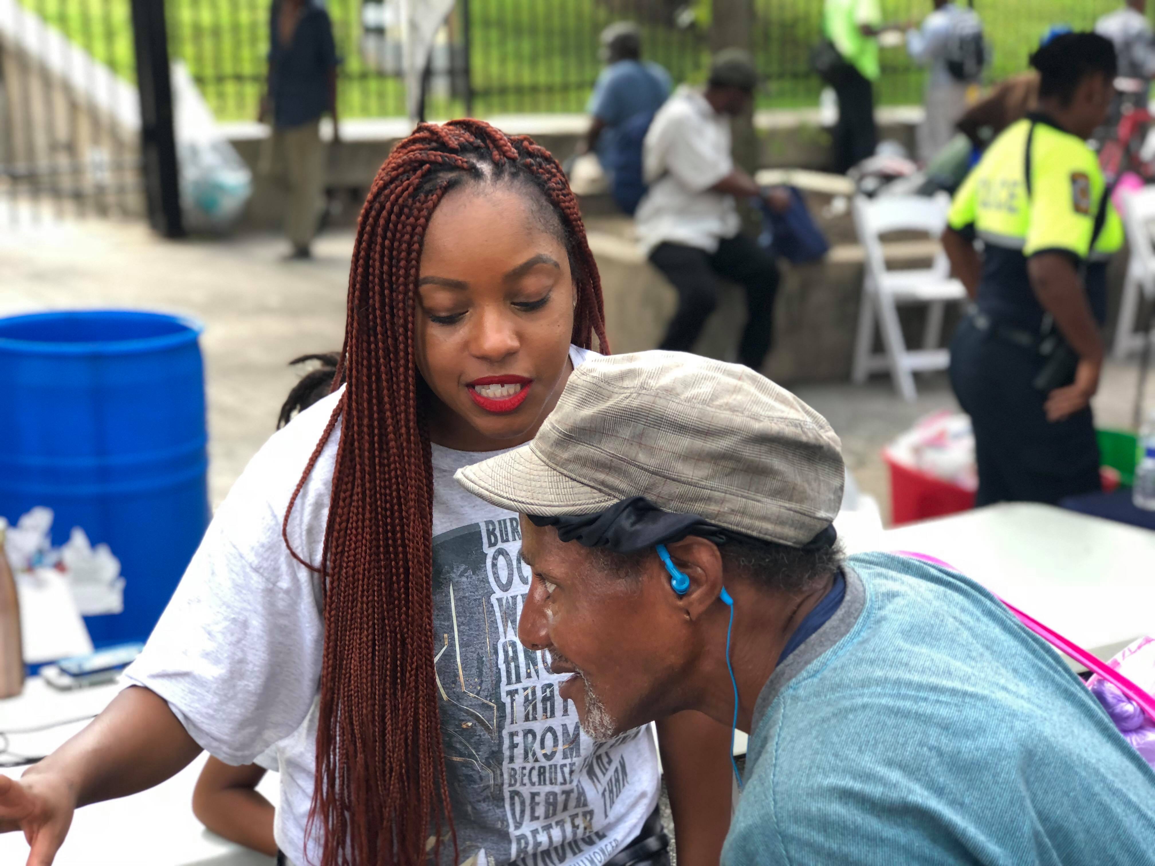 A Jo-Anne's House volunteer leaning in to talk with an older man at the outreach