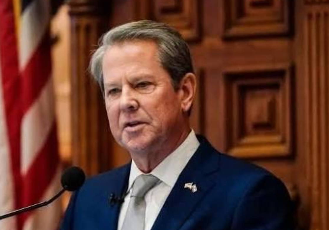 Georgia Governor Brian Kemp speaking at a podium in front of an American flag