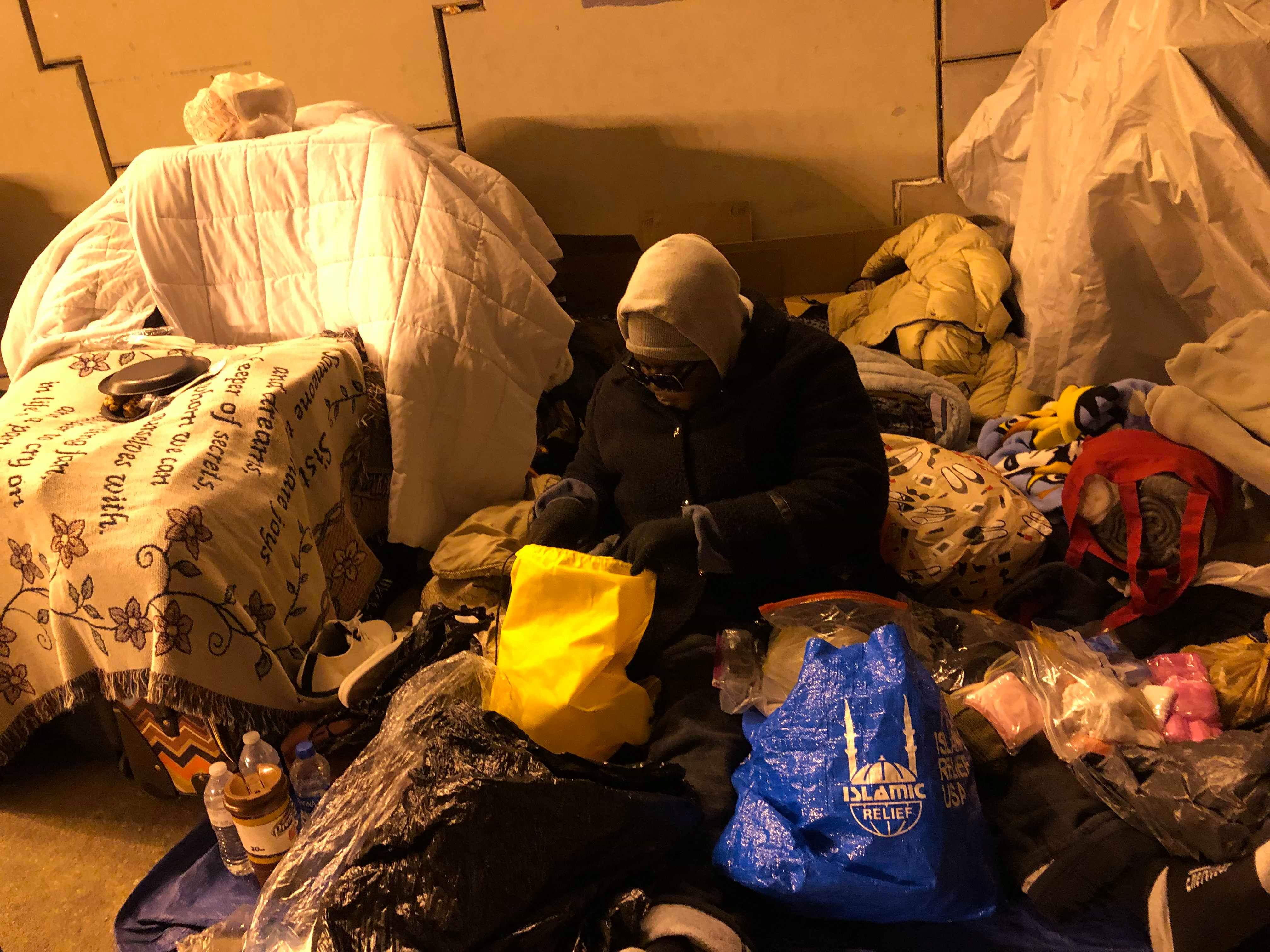 A participant sorting supplies and donation bags among the bedding