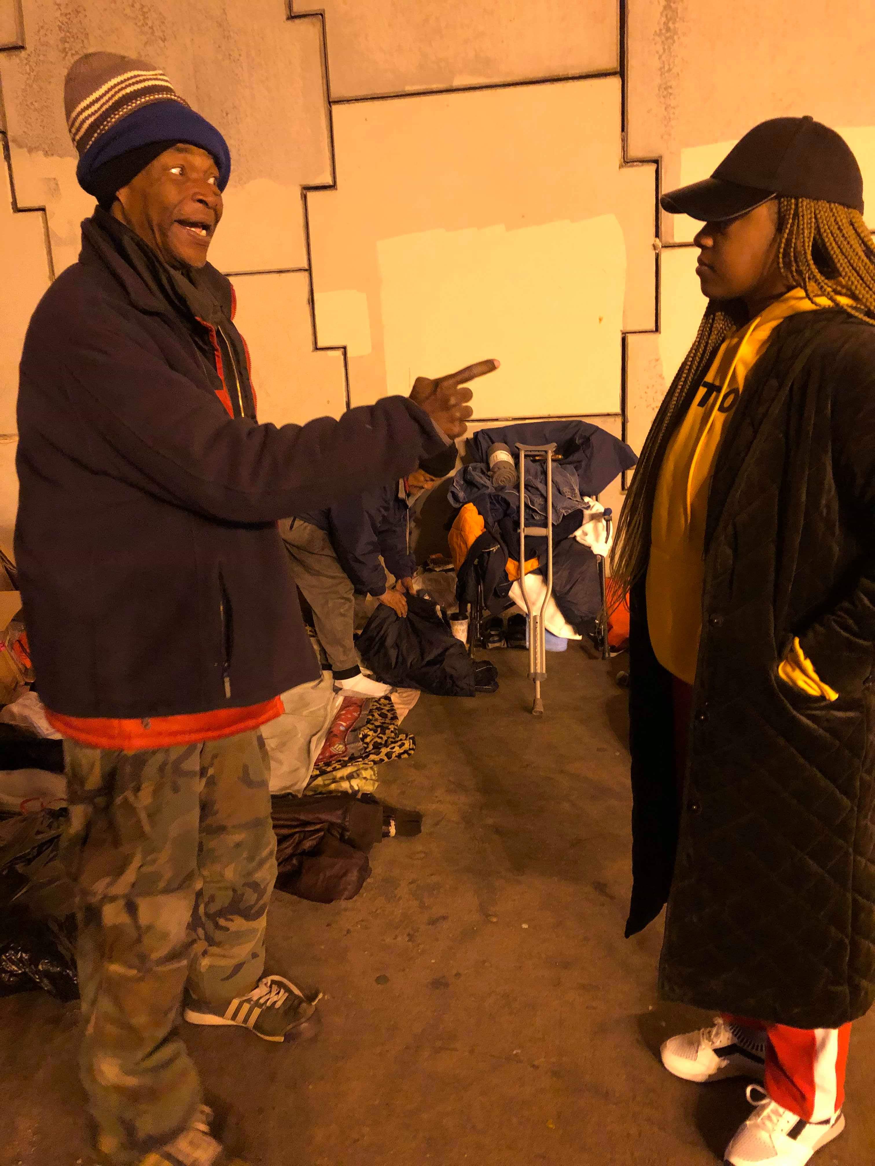 A resident sharing his story with a volunteer near his belongings