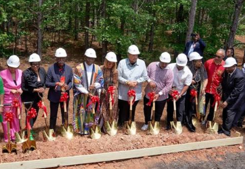 Faith and community leaders in hard hats break ground on the New Birth Village homeownership community in Stonecrest