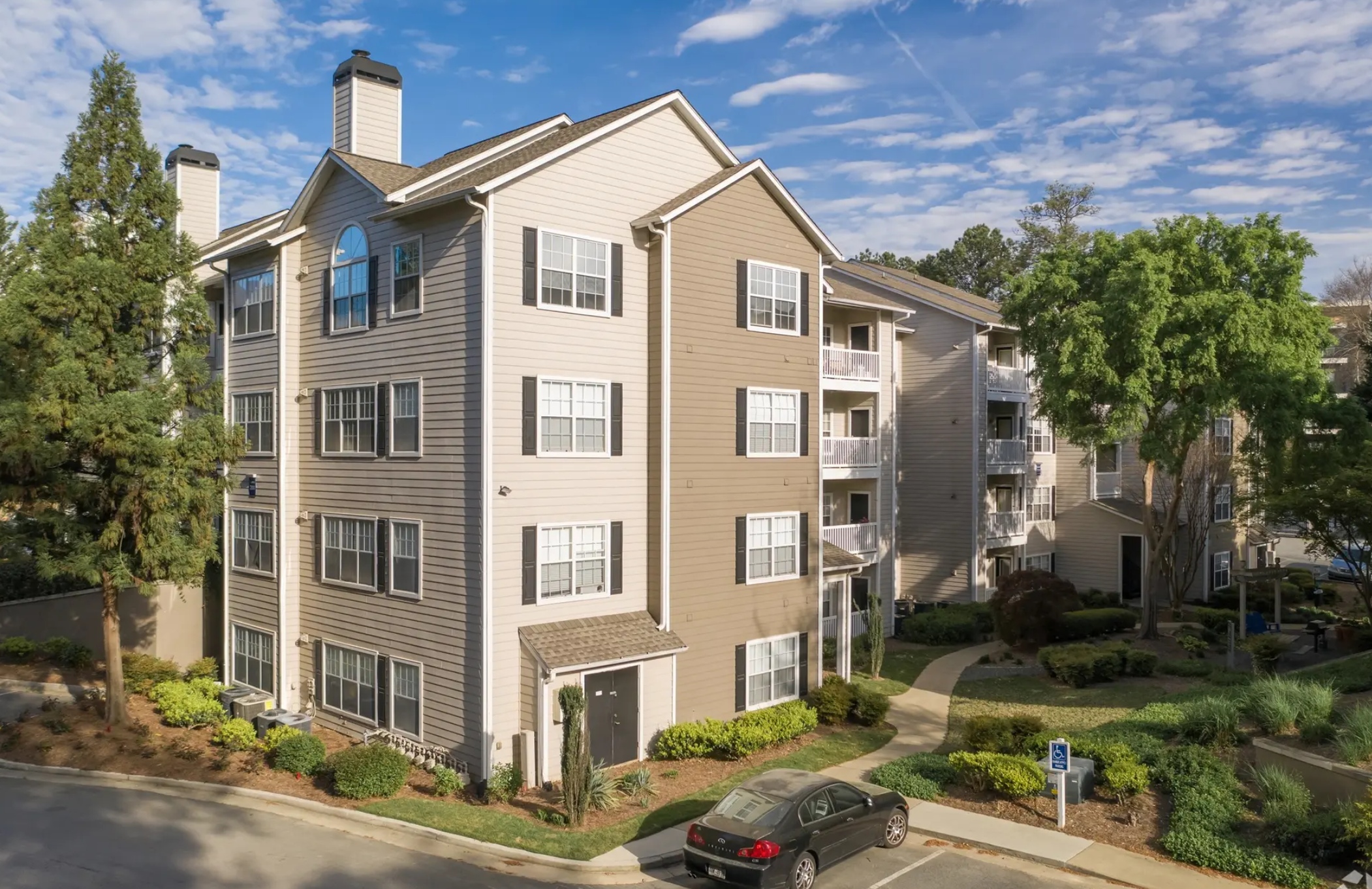 Park Summit Apartments, a four-story tan apartment building surrounded by trees and landscaping in Decatur