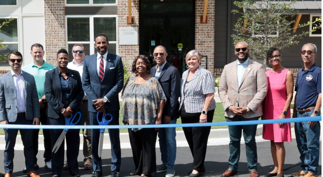 Officials cut a blue ribbon at the grand opening of the Flats and Villas at Stone Hogan in Greenbriar