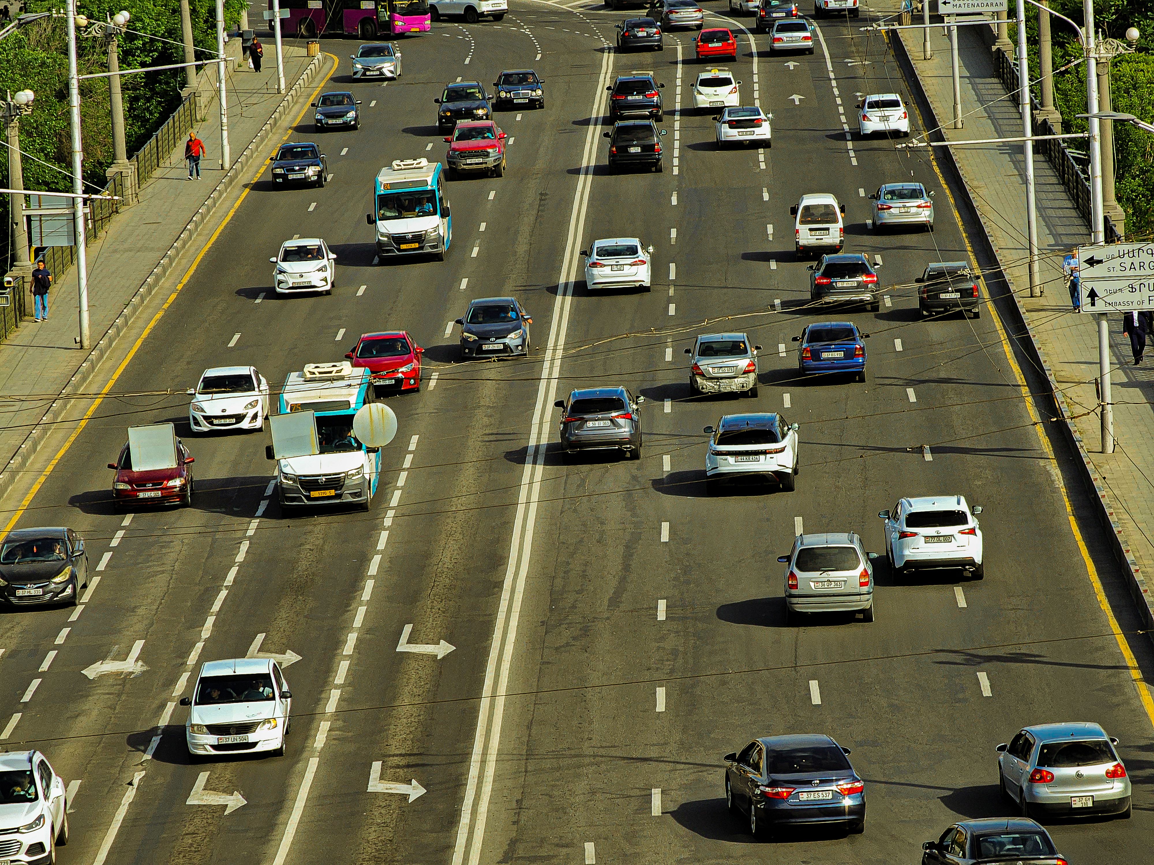 An aerial view of a busy multi-lane highway full of cars in heavy traffic