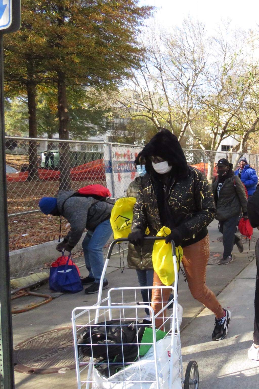 Community members with carts and yellow and red Jo-Anne's House care bags at the outreach site